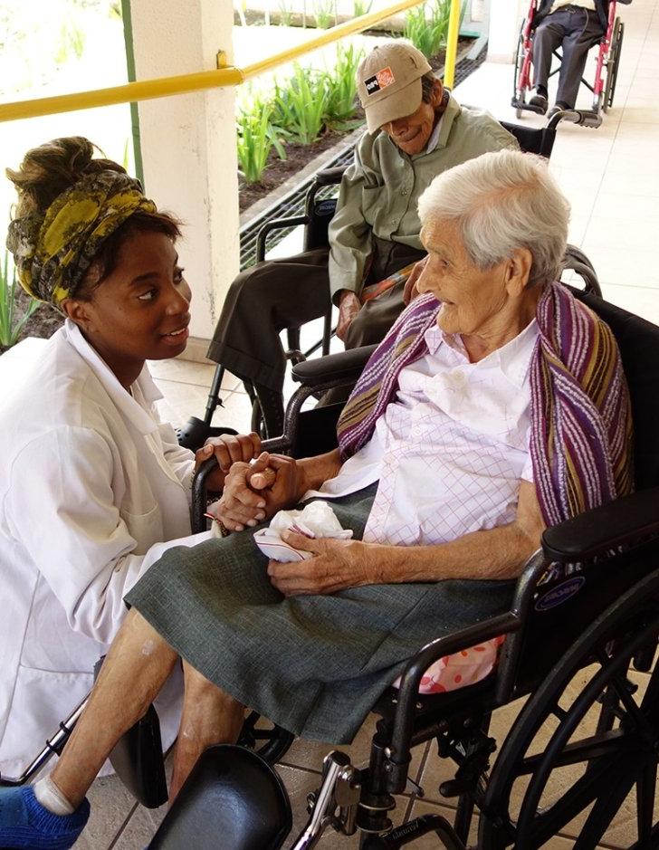 A Pitzer student helps a person in a wheelchair